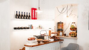 Zona de bar con botellas de vino, copas y diferentes opciones de comida a la vista.