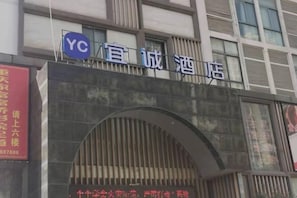 A hotel entrance with a sign that reads 'YC' and 'Yuan Cheng Hotel'. - Yicheng Hotel (Henan University of Technology) (Zhengzhou)