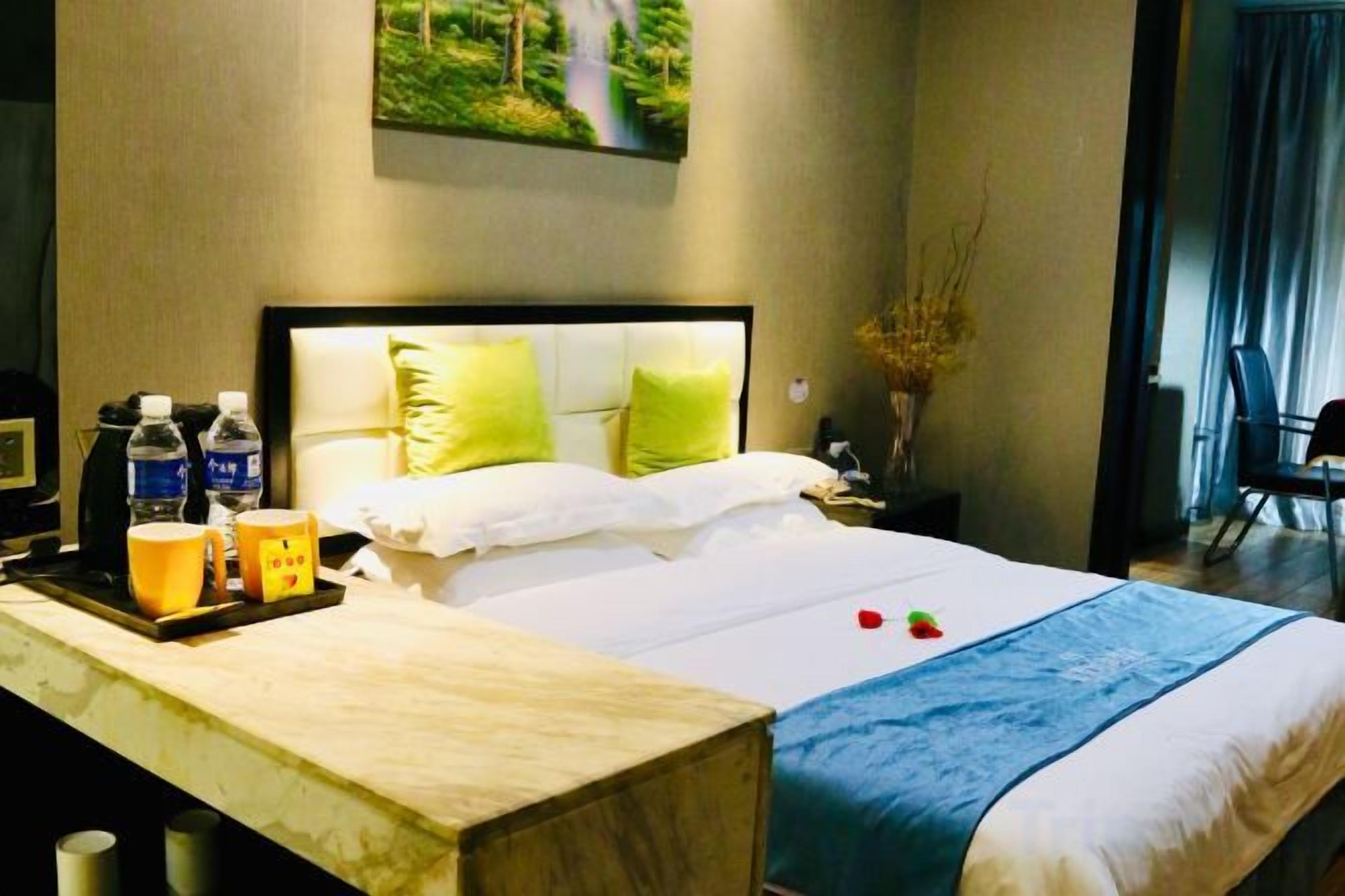 Quarto de hotel com cama, mesa de cabeceira e vista para o exterior.