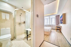 A modern bathroom with a glass shower enclosure, a toilet, and a sink.