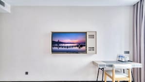 Une pièce au décor minimaliste, comprenant un bureau, une chaise et un tableau représentant un coucher de soleil sur un pont.
