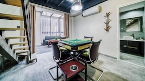 Une pièce avec une table de billard, un escalier en bois et une vue sur l’extérieur.
