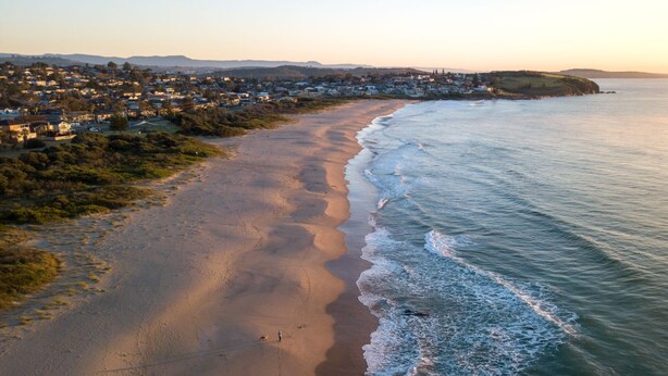 Une ville côtière dotée d’une plage de sable et bordée par l’océan.