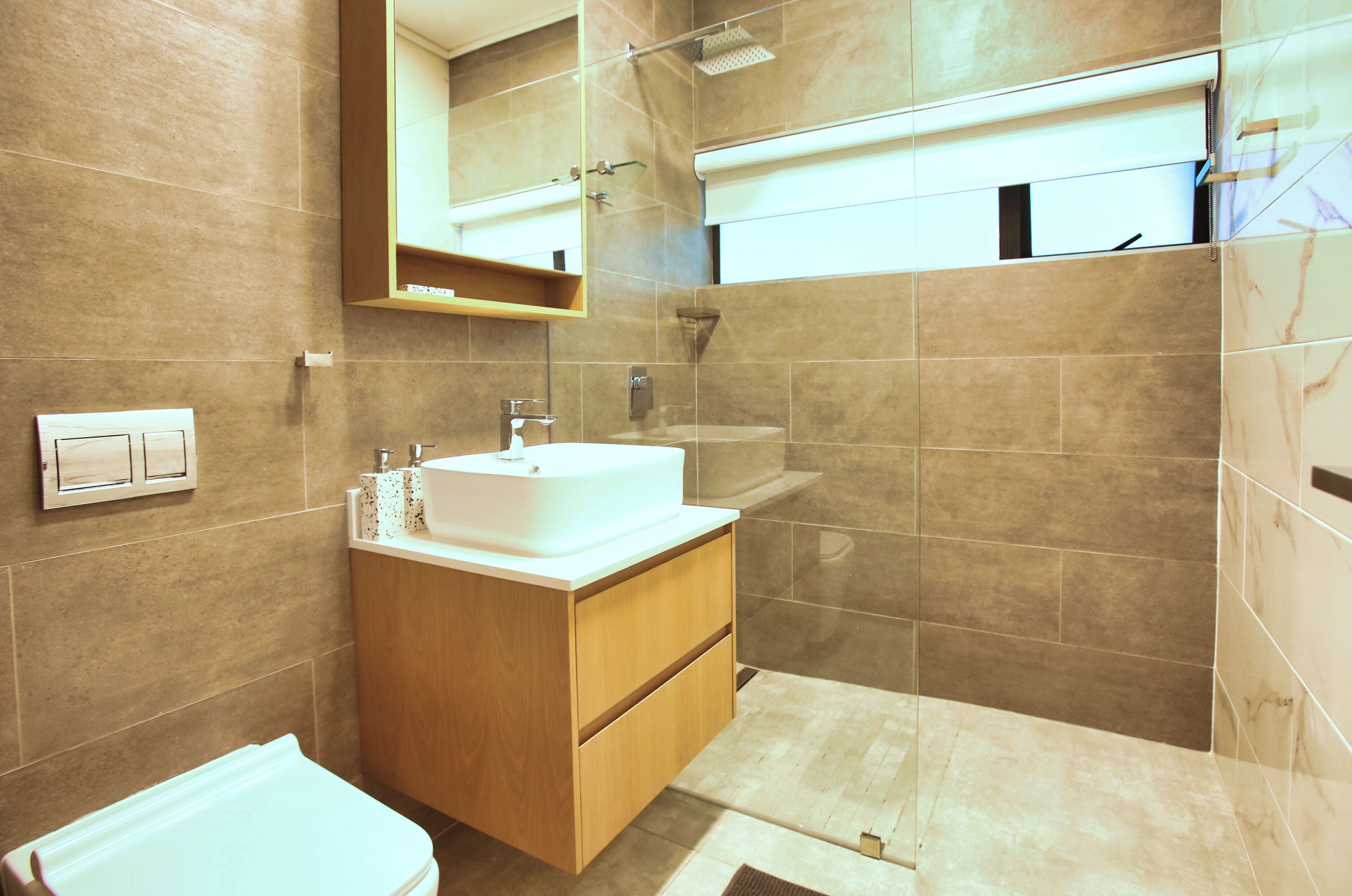 A modern bathroom with a sink, mirror, and shower.