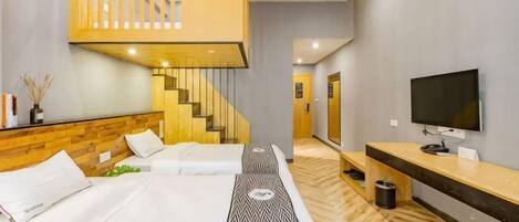 A hotel room with a bed, a TV, a wooden staircase, and a hallway.