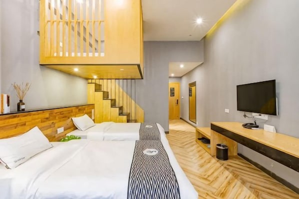 A hotel room with a bed, a TV, a wooden staircase, and a hallway. - Mangguo Hotel (Meilan Airport Branch, Haikou) (Haikou)