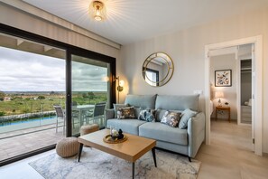 Relax in this stylish living room with a sofa, coffee table, and large sliding door leading to an outdoor terrace.