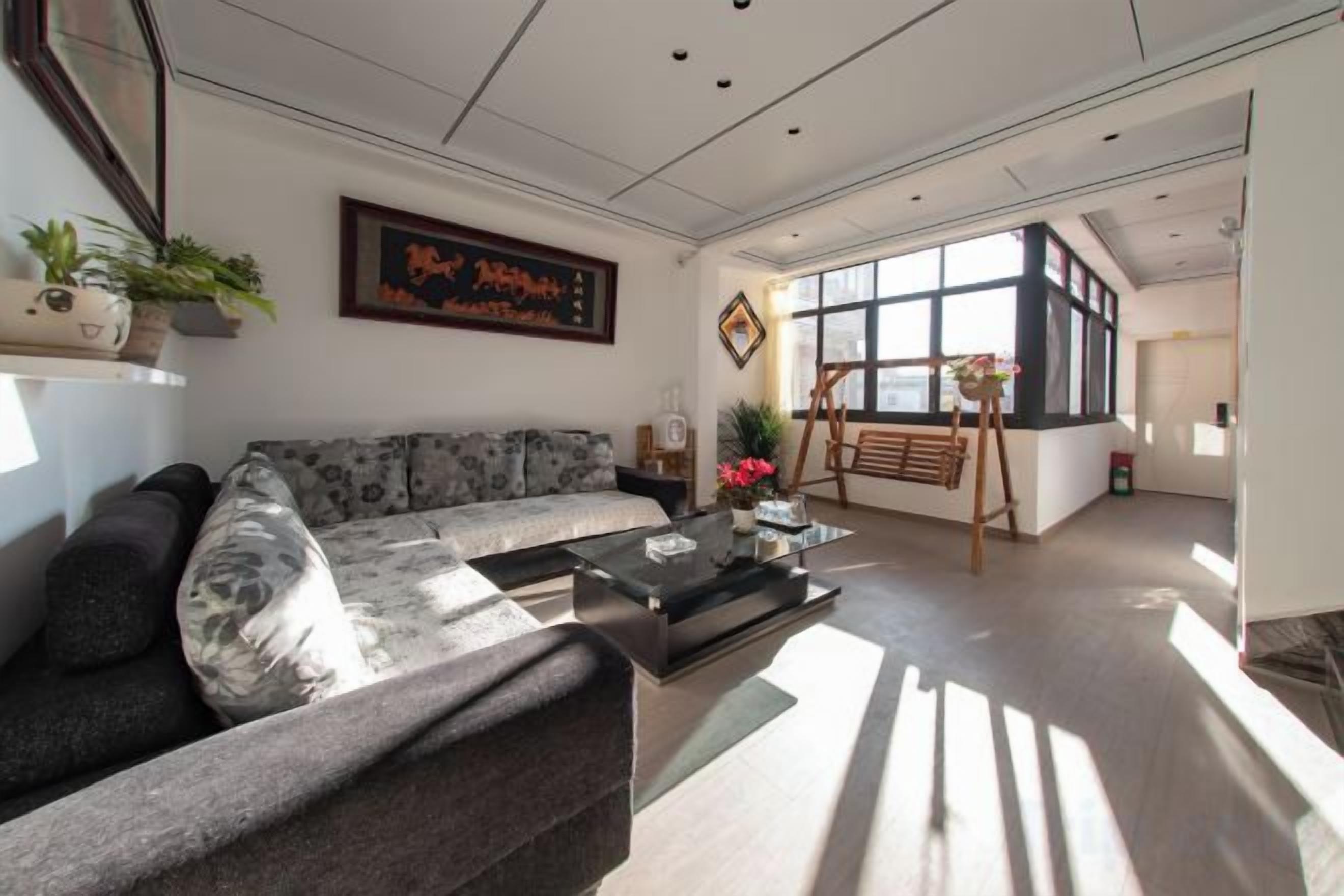 A modern living room with a sofa, coffee table, and artwork on the wall.