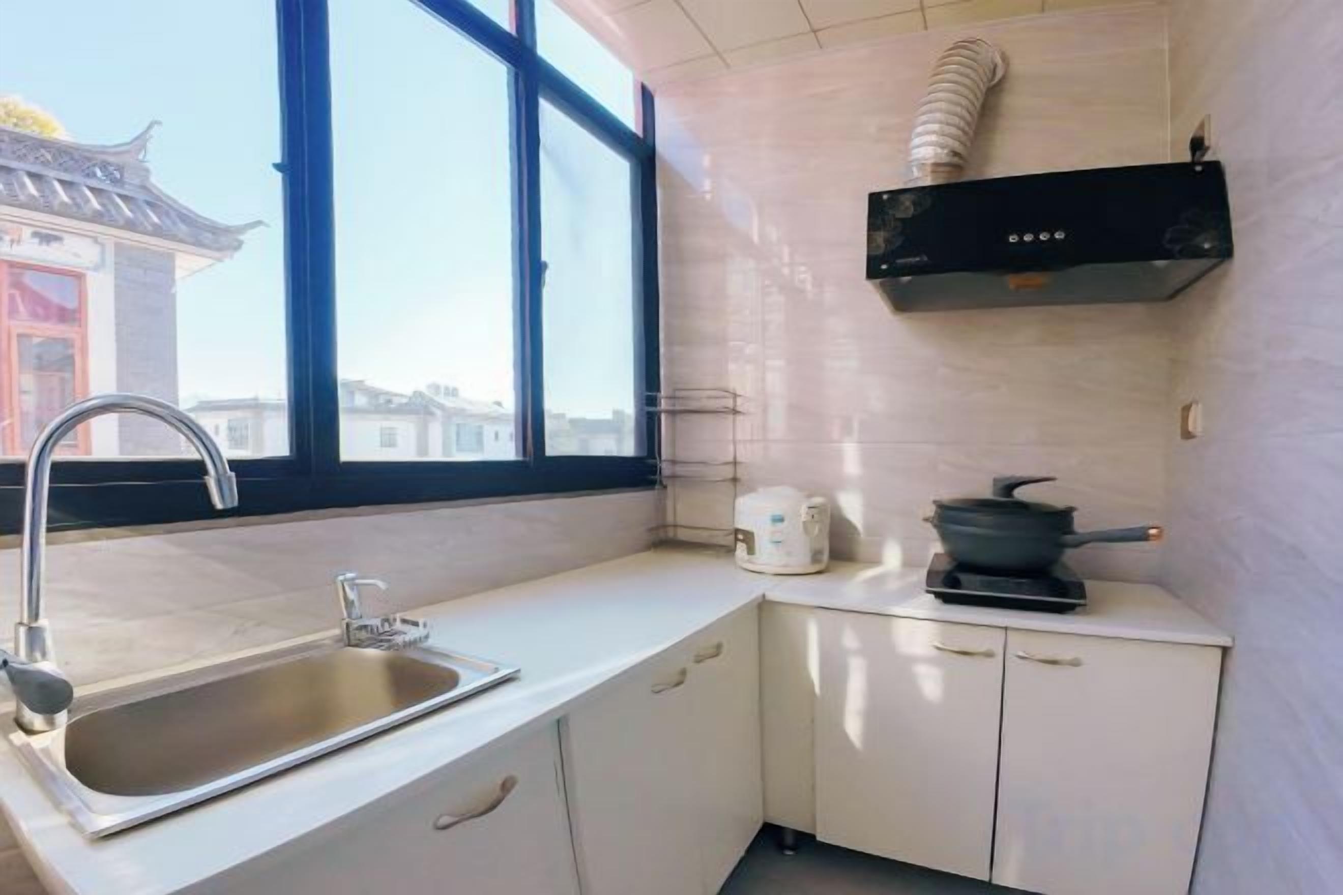 A kitchen with a sink, stove, and window.