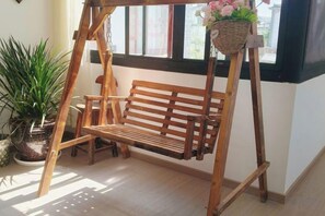 A wooden swing with a basket hanging from it, positioned near a window with a view of the outside. - Dali · Easeful Joy Aesthetic Designer's Holiday View Villa (Caicun Village, Erhai Lake Branch) (Dali City)
