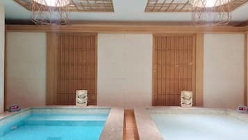 Dos piscinas separadas con paneles de madera y estatuas de piedra.
