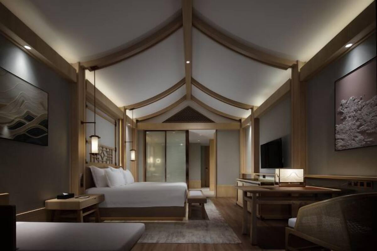 Een moderne hotelkamer met een groot bed, een bureau en een televisie.