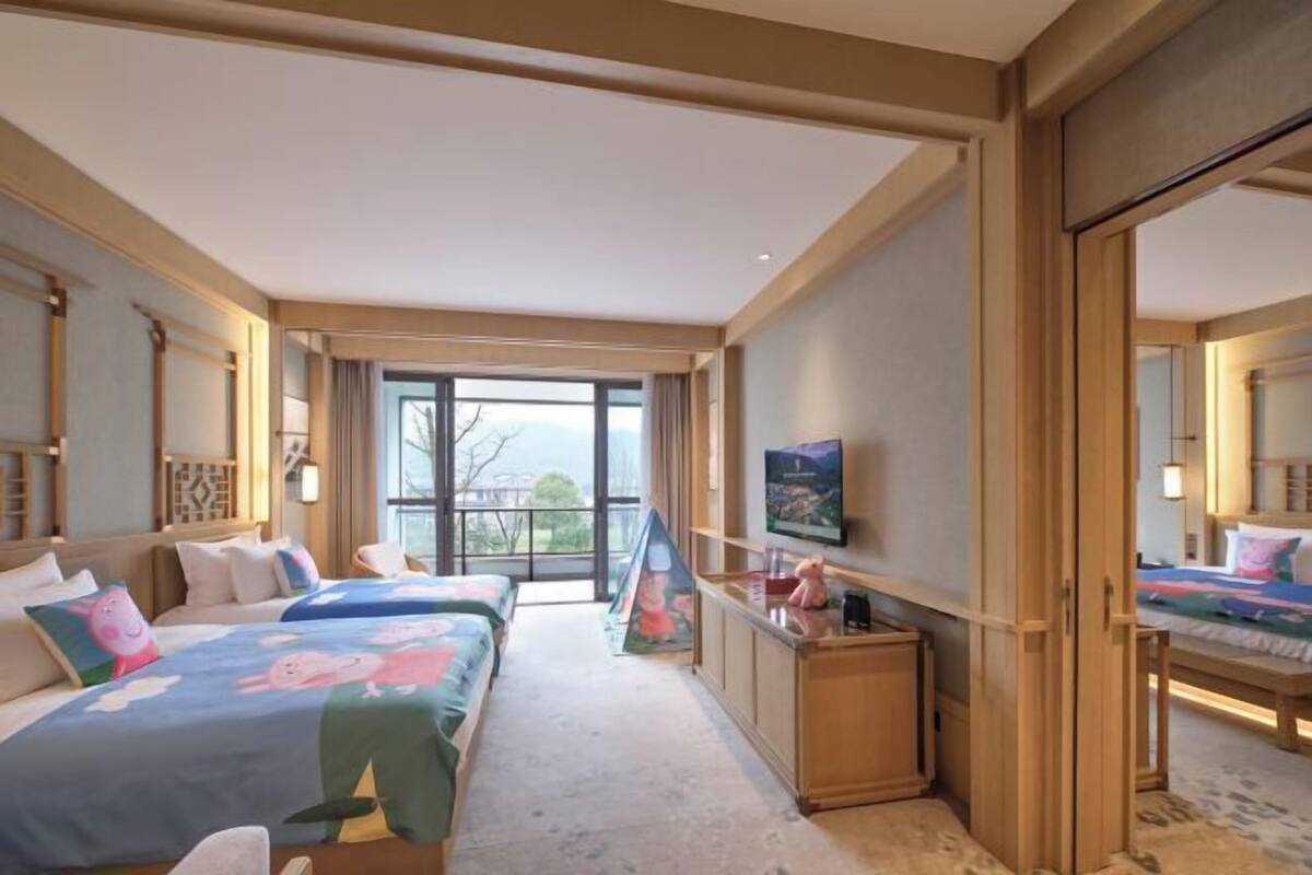Een hotelkamer met twee bedden, een televisie, een bureau en een balkon.