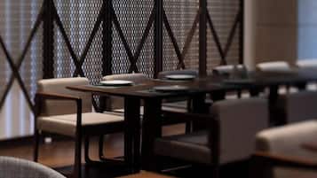 Een restaurant met tafels, stoelen, een behangetabel en een raam.