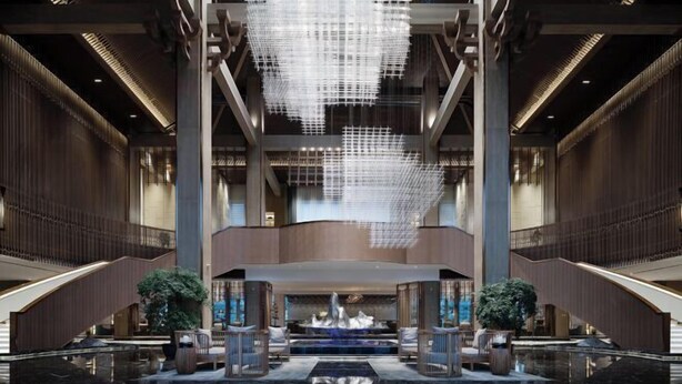 A spacious lobby with a large, modern chandelier, a central water feature, and multiple seating areas. - YunXi DengYun Resort Hotel (Xianju)