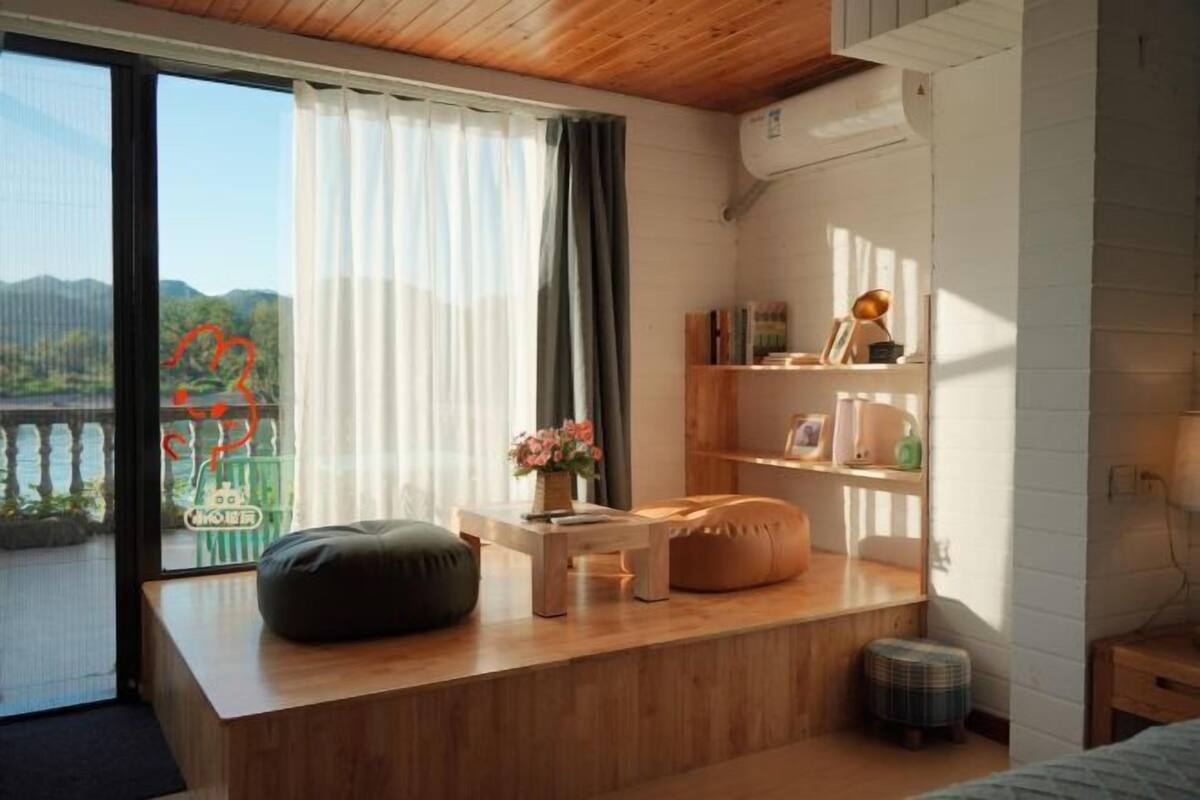 Camera da letto moderna con una scrivania in legno, un pouf, uno sgabello e una libreria.