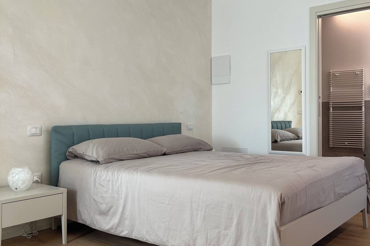 Une chambre à coucher avec un lit, une table de chevet et une commode.