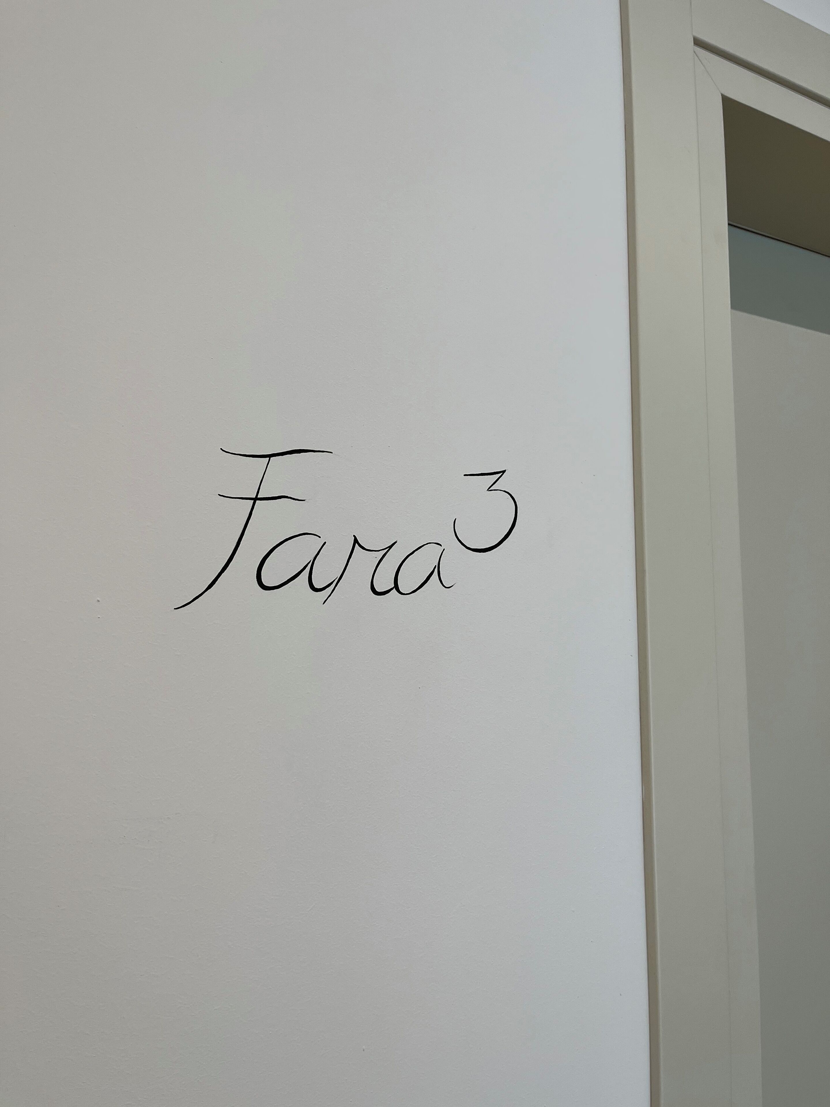 A white wall with the name "Fara" written in cursive.