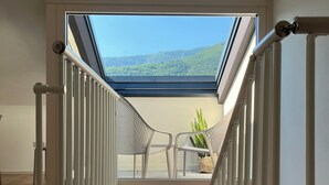A modern staircase with a glass balcony, white railings, and a view of a green landscape. - Alle Colline (Valdobbiadene)