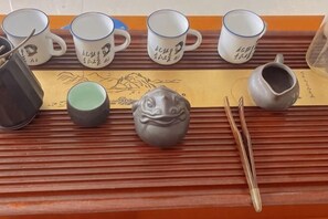 Una bandeja con tazas de cerámica, una tetera y palillos.
