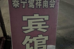 A sign with large Chinese characters, likely indicating a hotel's name or location. - Taining Luxiang Nanhui Hotel (Jinhu Prairie) (Taining)