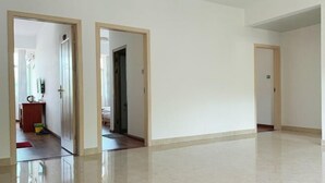 A spacious, empty room with a polished floor, a door leading to another room, and a visible door frame. - Taining Luxiang Nanhui Hotel (Jinhu Prairie) (Taining)