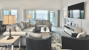 A living room with a sofa set, a coffee table, a TV, and a ceiling fan. - Lost Shaker of Salt - 3/3 w/ 4-Seater Golf Cart in Moultrie Creek, The Villages! (The Villages)