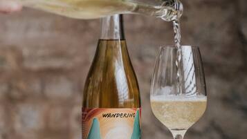 A bottle of wine being poured into a glass.