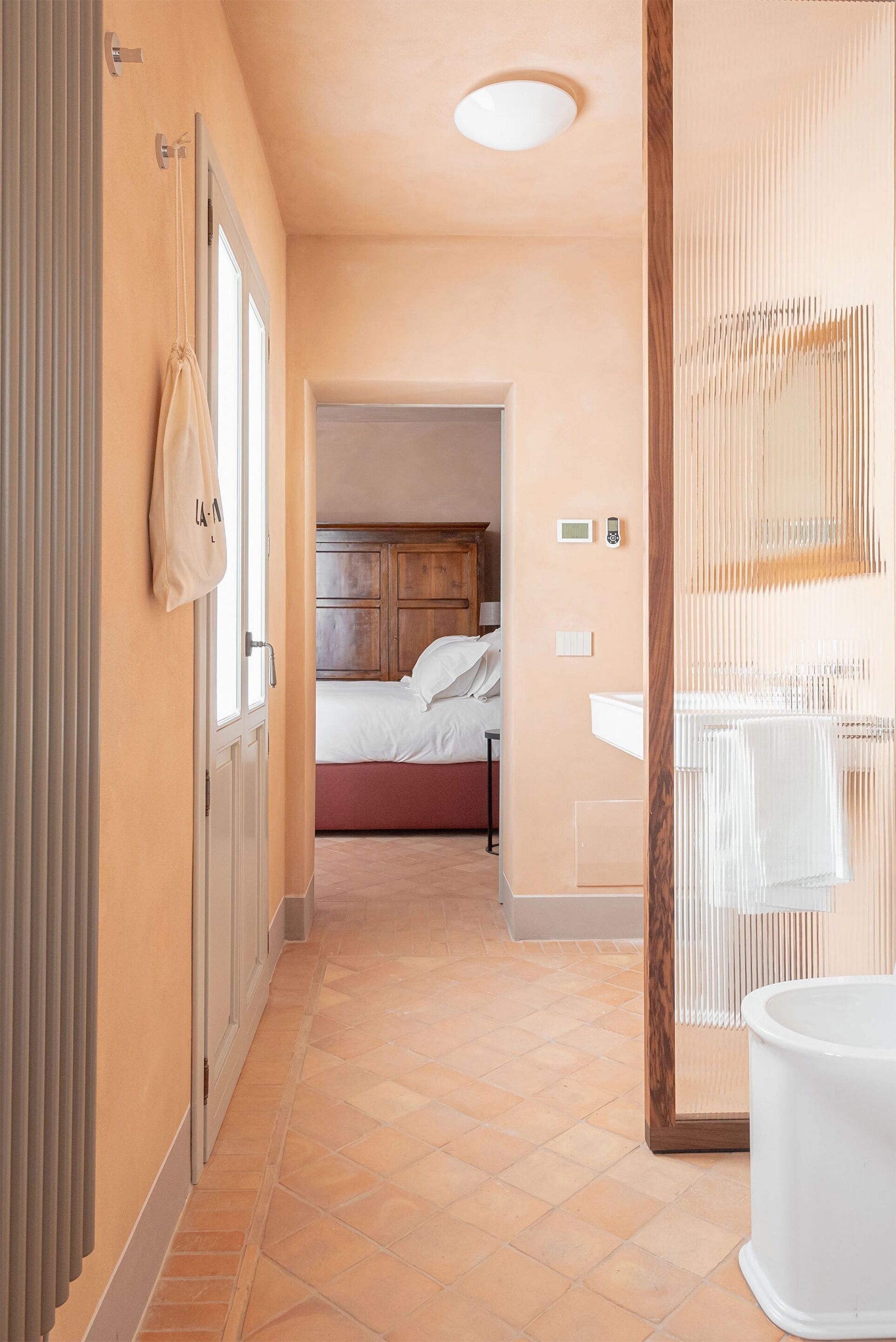 Ein Hotelgang mit einem Bett, einem Badezimmer und einer Toilette.