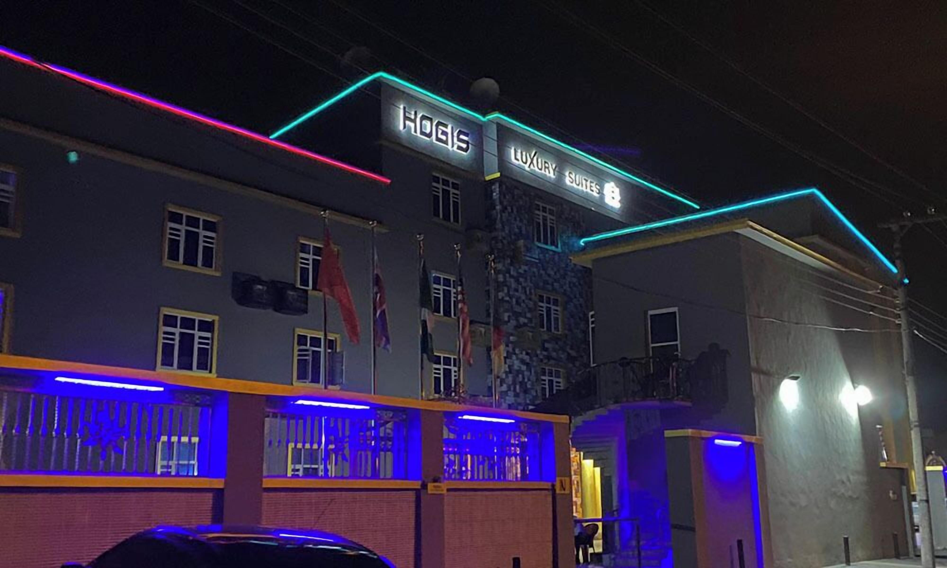 A building with a sign that reads "HOGIS LUXURY SUITES".