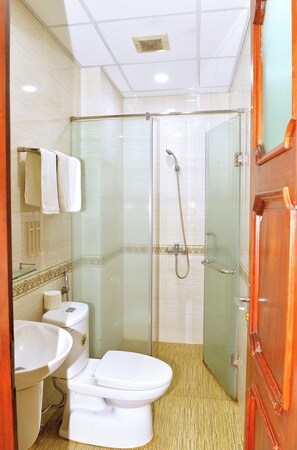 A bathroom with a toilet, sink, and shower.