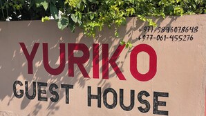 A sign for Yuriko Guest House with contact numbers. - Yuriko Guest House (Pokhara)