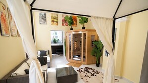 Een moderne woonkamer met een salontafel met glazen blad, een bank, een kast met glazen deuren en een kussen van runderhuid.