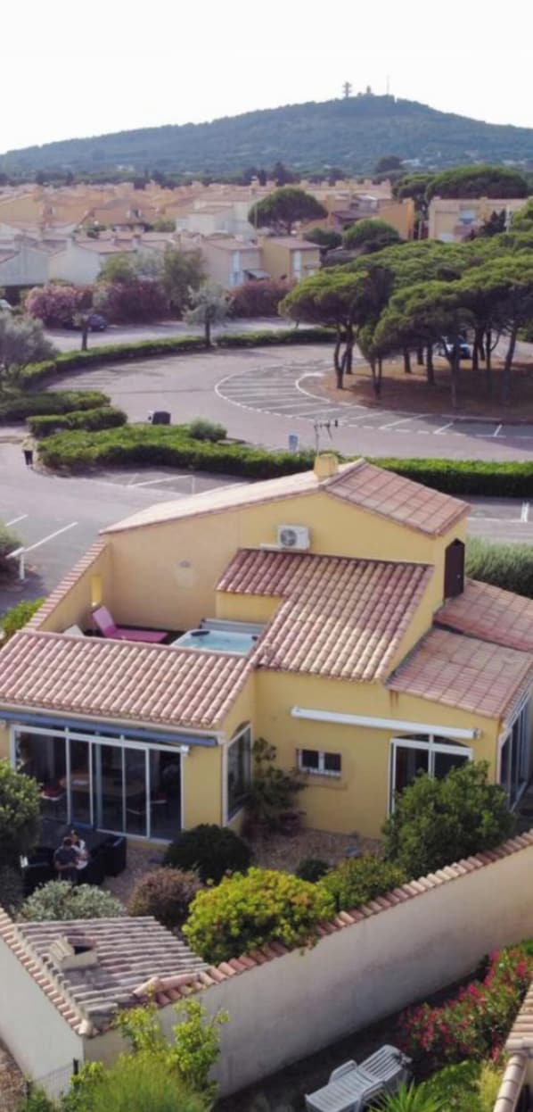 Un immeuble résidentiel doté d’un toit en tuiles, d’un balcon et d’un espace jardin.