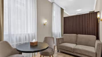 Un salon moderne avec une table ronde, deux fauteuils et un canapé.