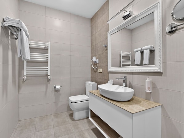 Un bagno moderno con WC, lavandino e porta asciugamani.