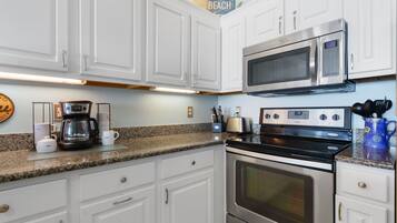 Condo com design assinado, 3 quartos, sacada, vista para a praia | Cozinha privada | Geladeira, micro-ondas, fogão, cooktop