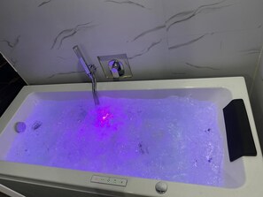 A bathtub with a control panel and a handheld showerhead. - Kingfisher resorts (Bichhiya)