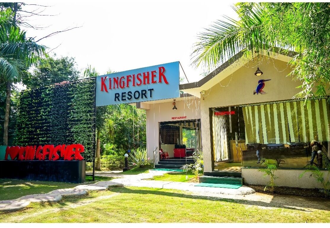 A resort named Kingfisher with a restaurant entrance and a signboard.