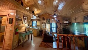 A cabin interior with a kitchen, dining area, and living room. - Lost In The Woods Cabin | Hochatown Cabin with Hot Tub, Fire Pit, Grill & Pets (Hochatown)