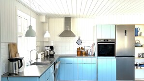 Een keuken met een centraal eiland, een fornuis en een koelkast.