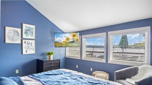 A bedroom with a bed, a chair, a dresser, and a TV on the wall. - Pet-Friendly Lakefront Home in a Quiet Cove w/ Netflix, Outdoor Seating, Boat Slip (Climax Springs)