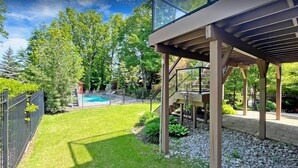 A backyard with a swimming pool, a covered patio, and a stone pathway. - Custom Built Home in Richmond Hill (Richmond Hill)