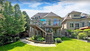 A two-story house with a balcony, a staircase, and a well-maintained garden. - Custom Built Home in Richmond Hill (Richmond Hill)