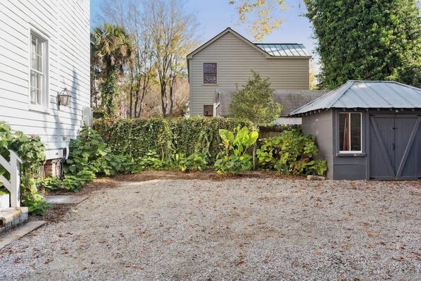 Une allée de gravier mène à une maison avec un abri de jardin.