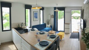 Eine moderne Küche mit Essbereich, einem blauen Sofa und einem kleinen Tisch für zwei Personen.