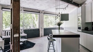 Une cuisine moderne dotée d’un coin bar, de grandes fenêtres et d’un design minimaliste.