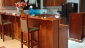 Une cuisine moderne avec des tabourets de bar en bois, des luminaires suspendus et un îlot central.