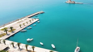 A marina with boats docked, a pier, and a lighthouse. - Naus Hotel (Nafplio)