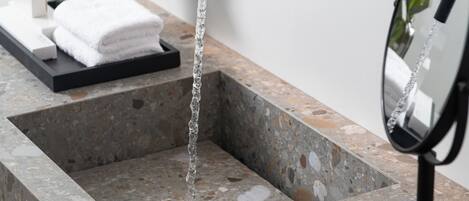 A bathroom with a granite countertop, a black faucet, and a mirror.